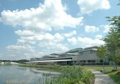 a large, white building at the edge of a body of water a large, white building at the edge of a body of water